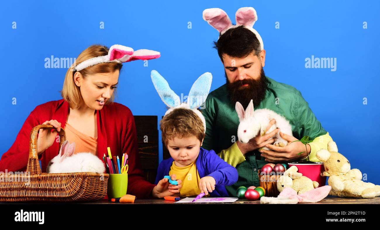Osterfamilie mit farbigen Ostereiern. Mutter, Vater und Sohn bereiten sich auf Ostern vor. Eltern und Kinder malen Eier für den Urlaub. Hasen Familie in Hase Stockfoto