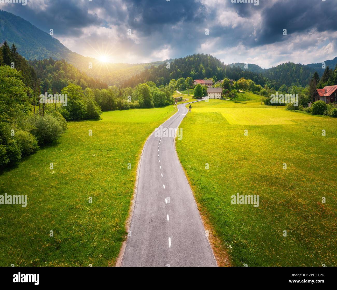 Luftaufnahme der Straße in grünen Wiesen und hils bei Sonnenuntergang im Sommer Stockfoto