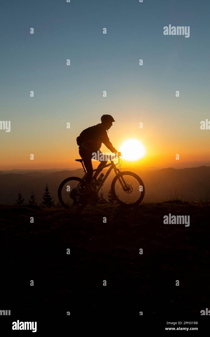 Silhouette eines Mountainbikers in Richtung eines wunderbaren Sonnenuntergangs Stockfoto