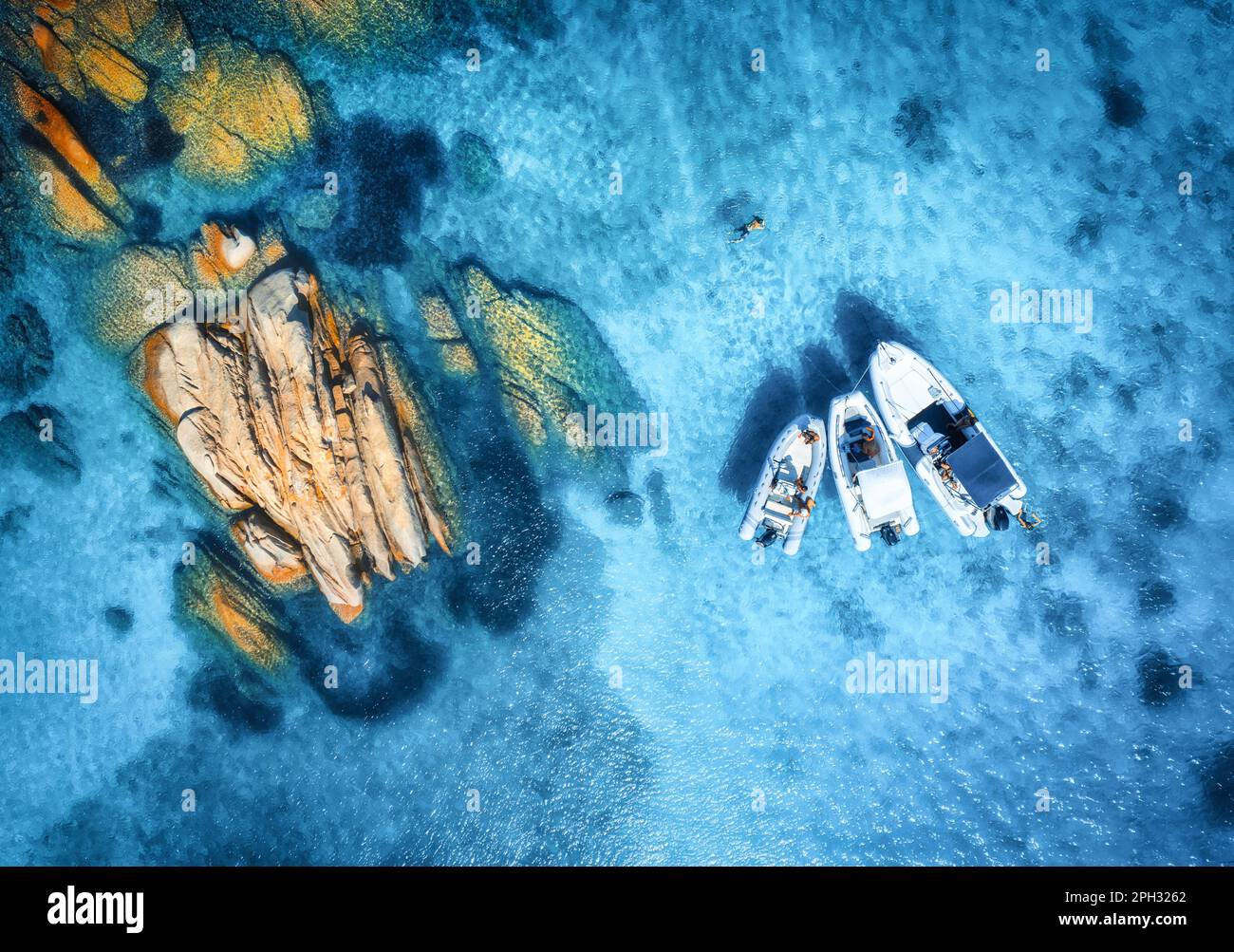 Luftaufnahme von wunderschönen Booten und Steinen im blauen Meer im Sommer Stockfoto