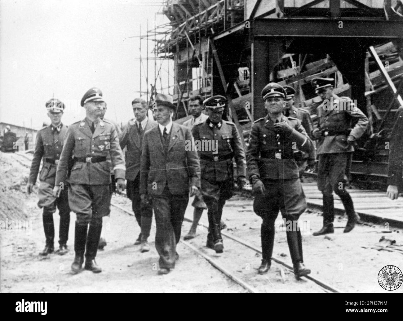 Heinrich Himmler (zweite Linke) besucht das Werk IG Farben im Konzentrationslager Auschwitz III, Juli 1942. IG Farben baute hier seine Synthesekautschukfabrik, da die Baustelle über gute Eisenbahnverbindungen und Zugang zu Rohstoffen sowie einen riesigen Pool unbezahlter Arbeiter verfügte. Stockfoto