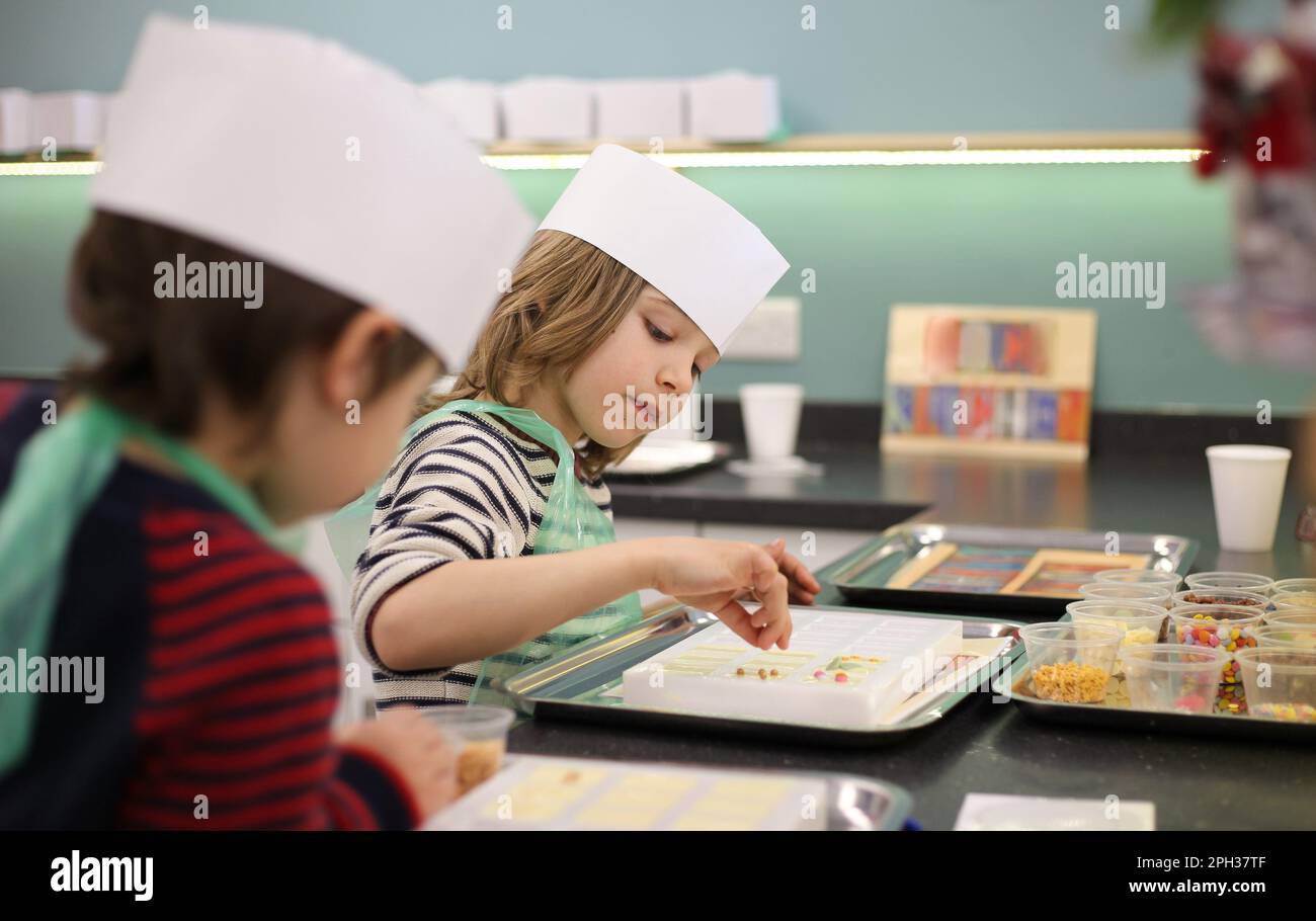 Kinder dekorieren Schokolade Stockfoto