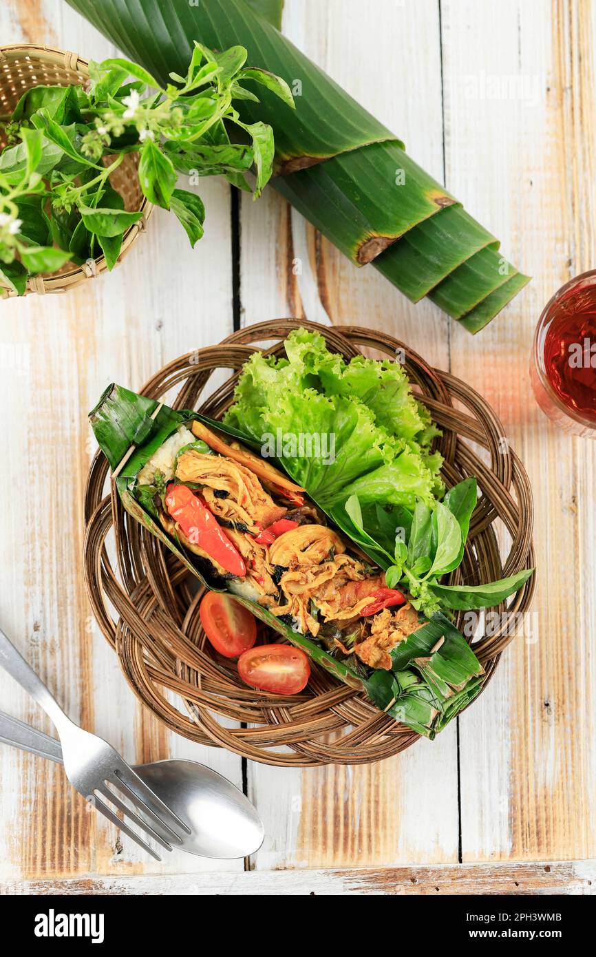 Nasi Bakar Ayam Suwir mit Kemangi, gedämpftem Reis mit gebratenem, würzigem Hähnchen und süßem Basilikumblatt, Umhang mit Bananenblatt und gegrilltem. Top Vie Stockfoto