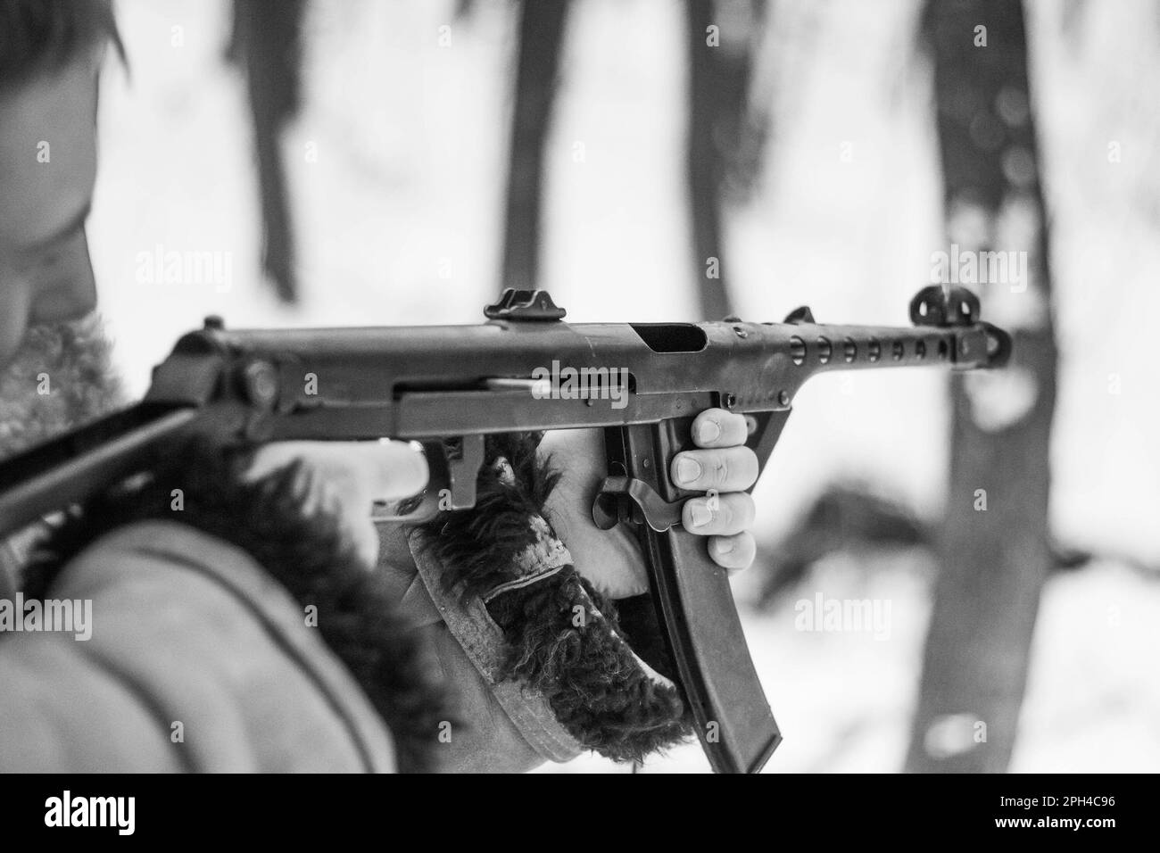 Retro-Foto eines Soldaten, der im Winterwald schießt Stockfoto