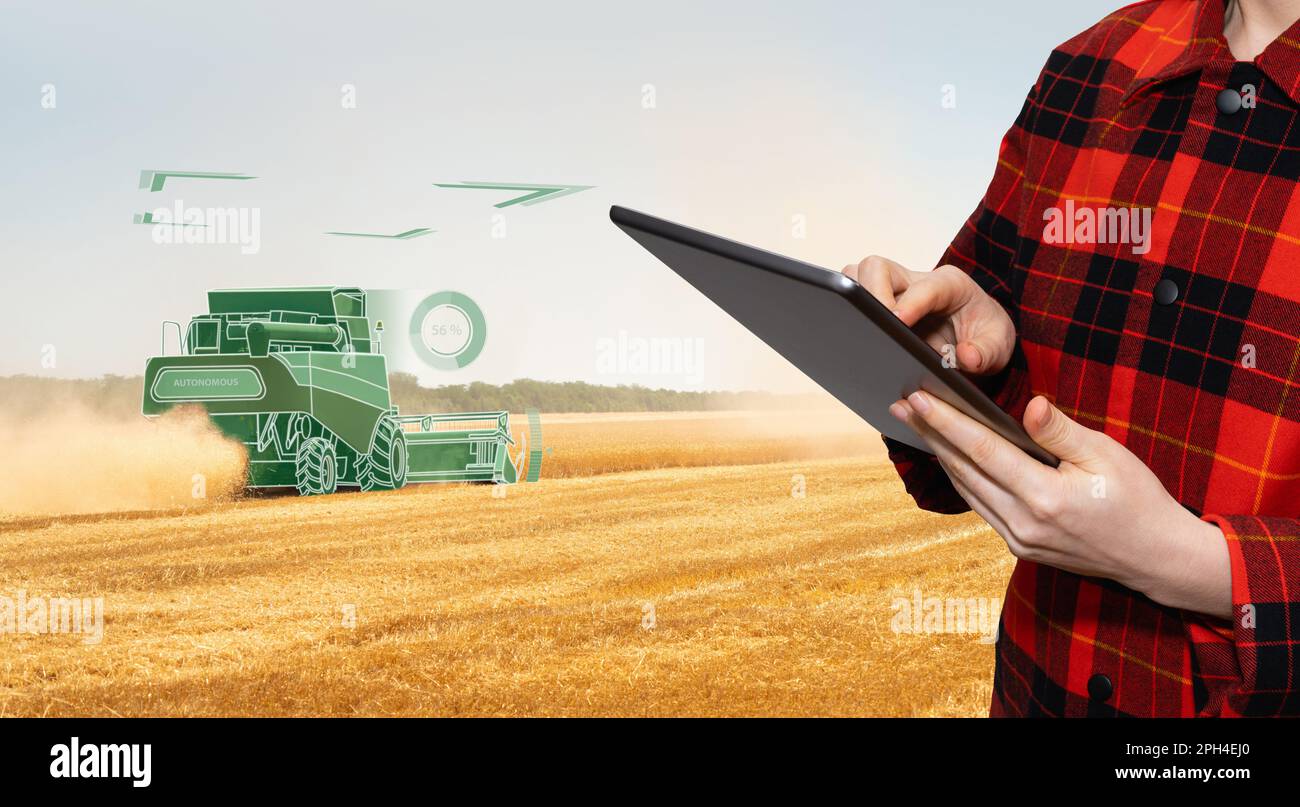 Landwirt nutzt ein digitales Tablet autonomen Harvester zu steuern. Smart Farming Konzept. Stockfoto