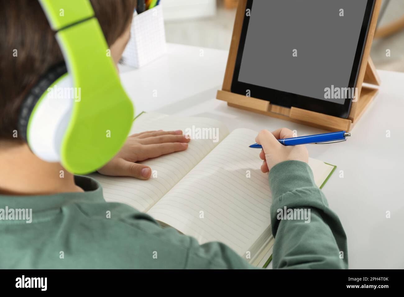 Süßer kleiner Junge mit modernem Tablet, der zu Hause online lernt, Nahaufnahme. E-Learning Stockfoto