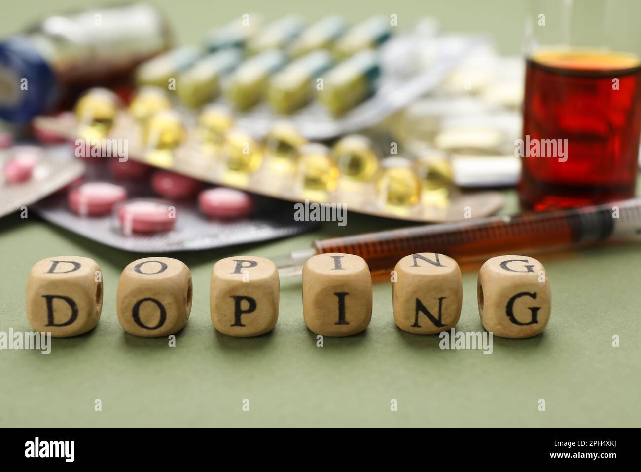 Holzwürfel mit Wort Doping und Drogen auf grünem Hintergrund, Nahaufnahme Stockfoto