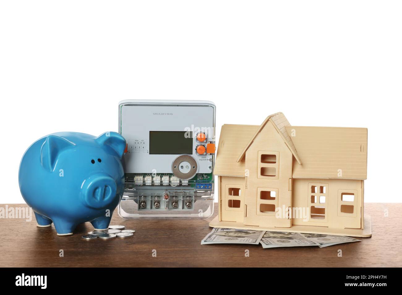 Stromzähler, Hausmodell und Sparschwein auf Holztisch vor weißem Hintergrund Stockfoto