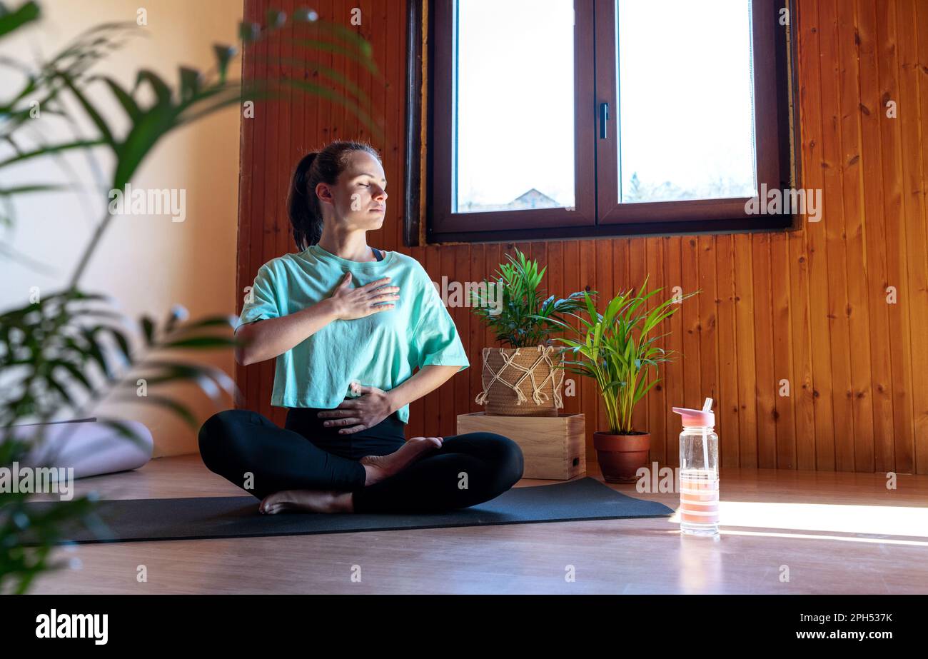 Weibliches mentales Wohlbefinden und Selbstbeherrschung mit Yoga-Atmung und Meditation zu Hause. Stockfoto