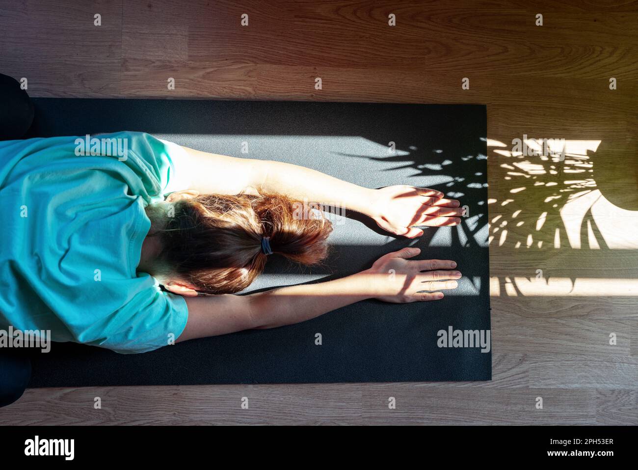 Selbstliebe mit gesundem Lebensstil, weibliche Person auf Yogamatte zu Hause. Stockfoto