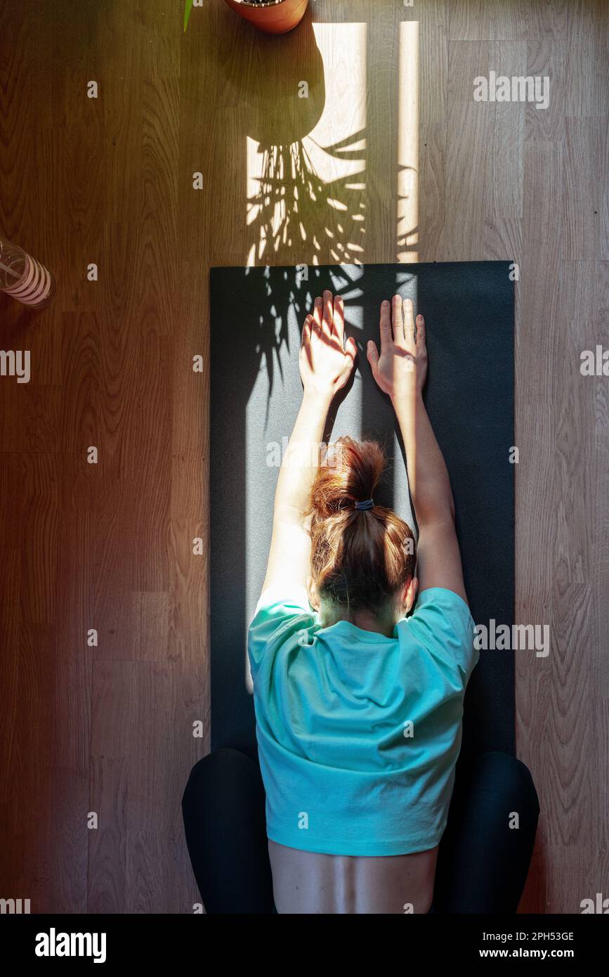 Selbstliebe mit gesundem Lebensstil, weibliche Person auf Yogamatte zu Hause. Stockfoto