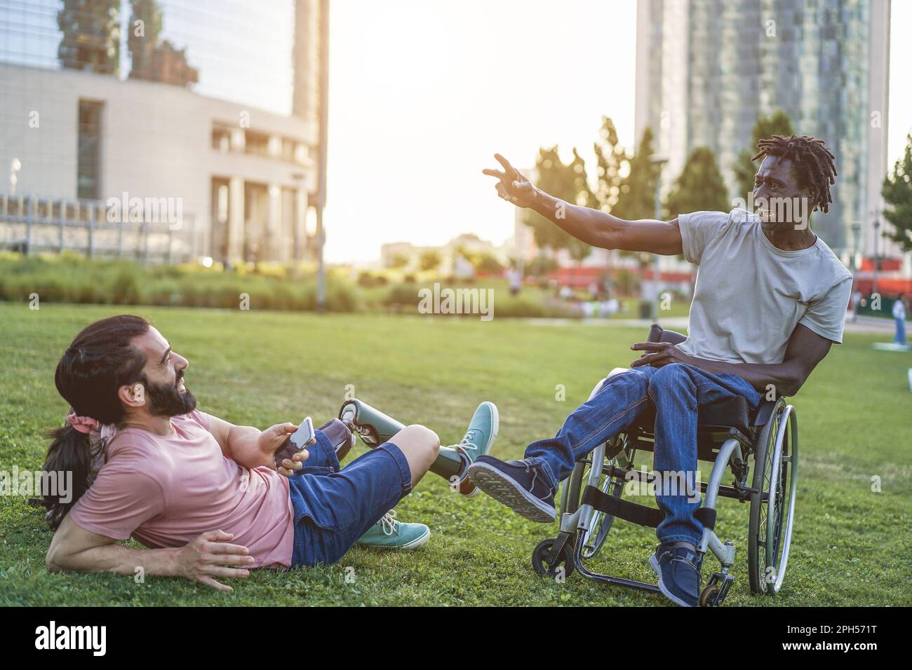 Fröhliche Freunde mit Behinderung, die Spaß im Park City haben - weicher Fokus auf das afrikanische Männergesicht Stockfoto