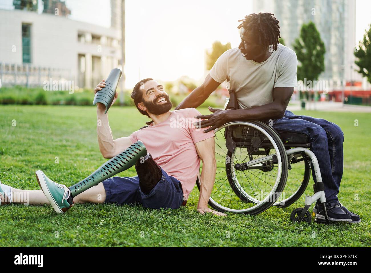 Glückliche Freunde mit Behinderung, die Spaß im Park City haben - Fokus auf afrikanischem Männergesicht Stockfoto
