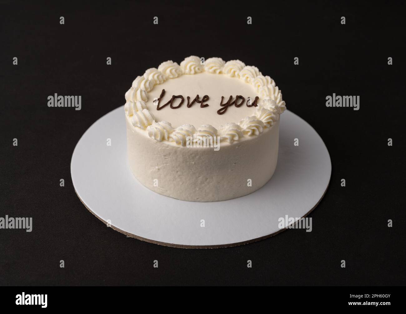Kleiner weißer Kuchen auf schwarzem Hintergrund Stockfoto