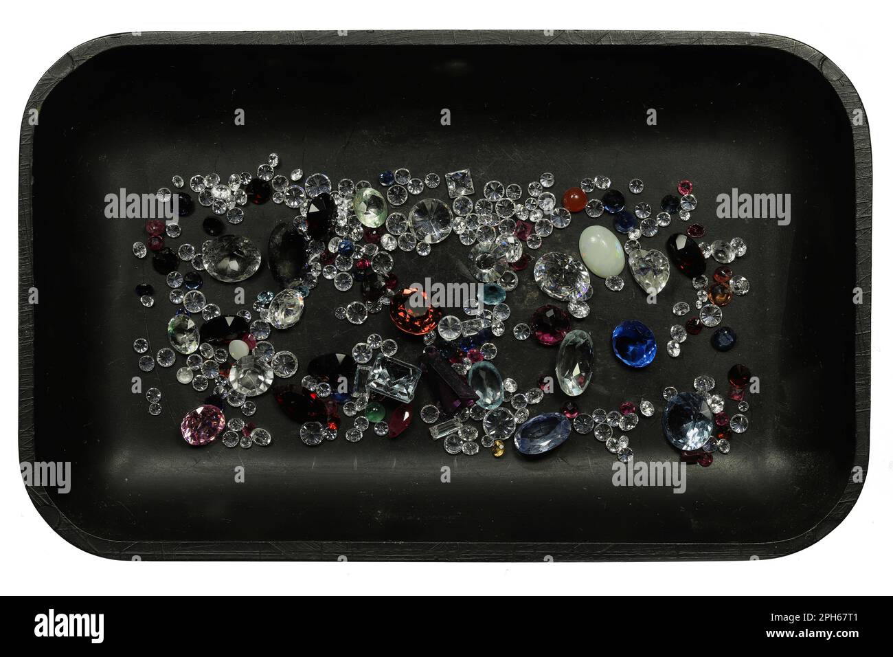 Verschiedene Edelsteine in schwarzem Tablett isoliert auf weißem Hintergrund Stockfoto