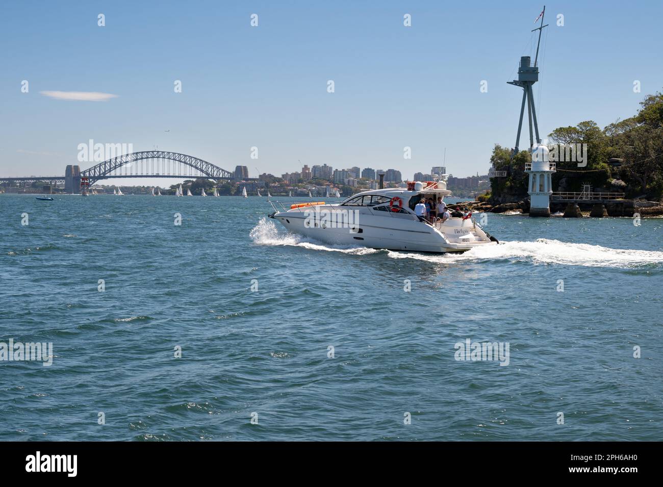 Ein Motorboot umrundet den Kirribilli Point vor dem Hintergrund der Harbour Bridge, New South Wales, Australien. Stockfoto