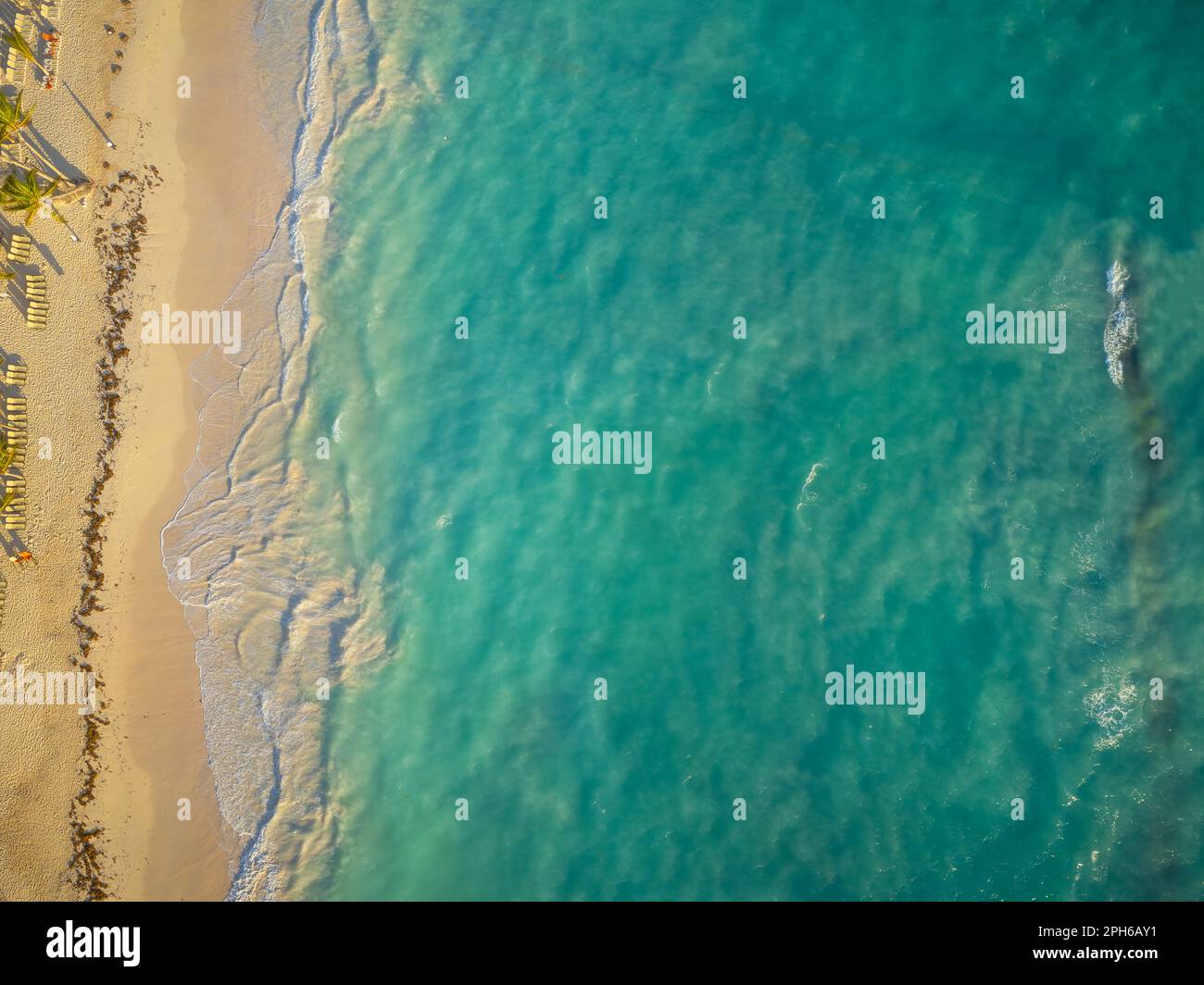 Schüsse von einer Drohne. Meer und Strand. Heller Sand mit Sonnenschirmen am Ufer, klares, transparentes smaragdfarbenes Meer mit leichten Wellen. Recreati Stockfoto