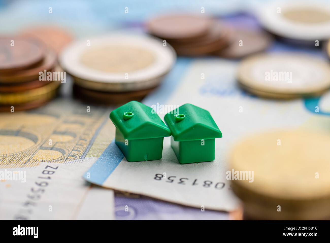 Kleines Haus in Münzstapeln, die die Hausfinanzierung darstellen Stockfoto