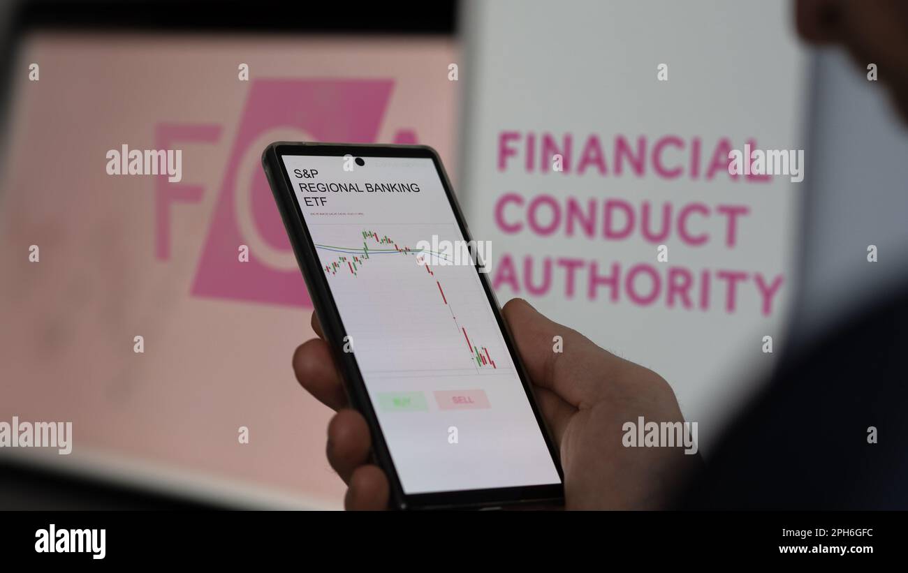 März 26. 2023: Ein Investor analysiert eine regionale Bank-ETF auf einem Bildschirm; das Logo der Financial Conduct Authority im Hintergrund. Stockfoto