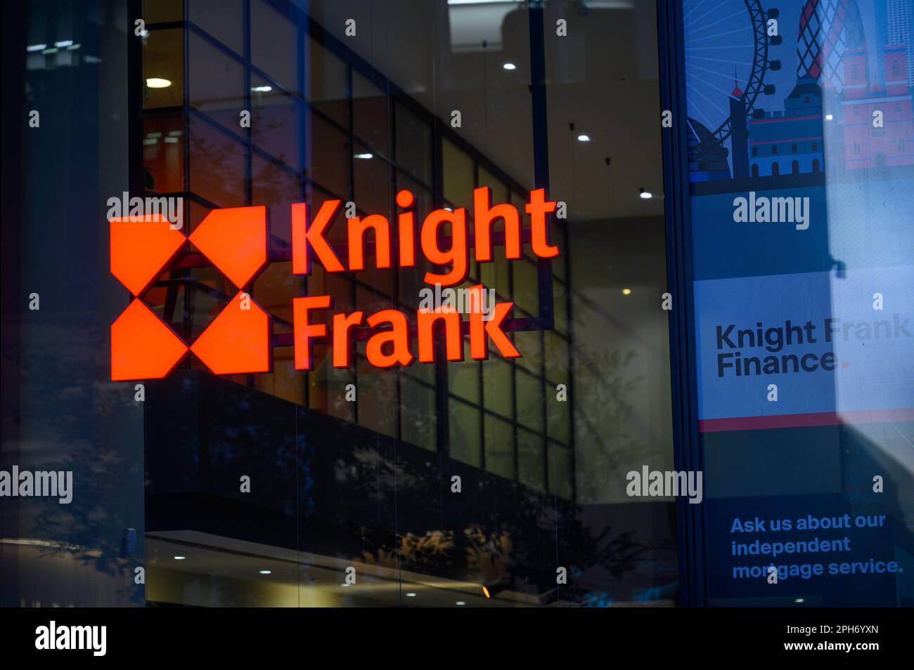 LONDON - 12. November 2022: Leuchtendes rotes Frank Knight-Schild, das im Fenster eines Gebäudes leuchtet Stockfoto