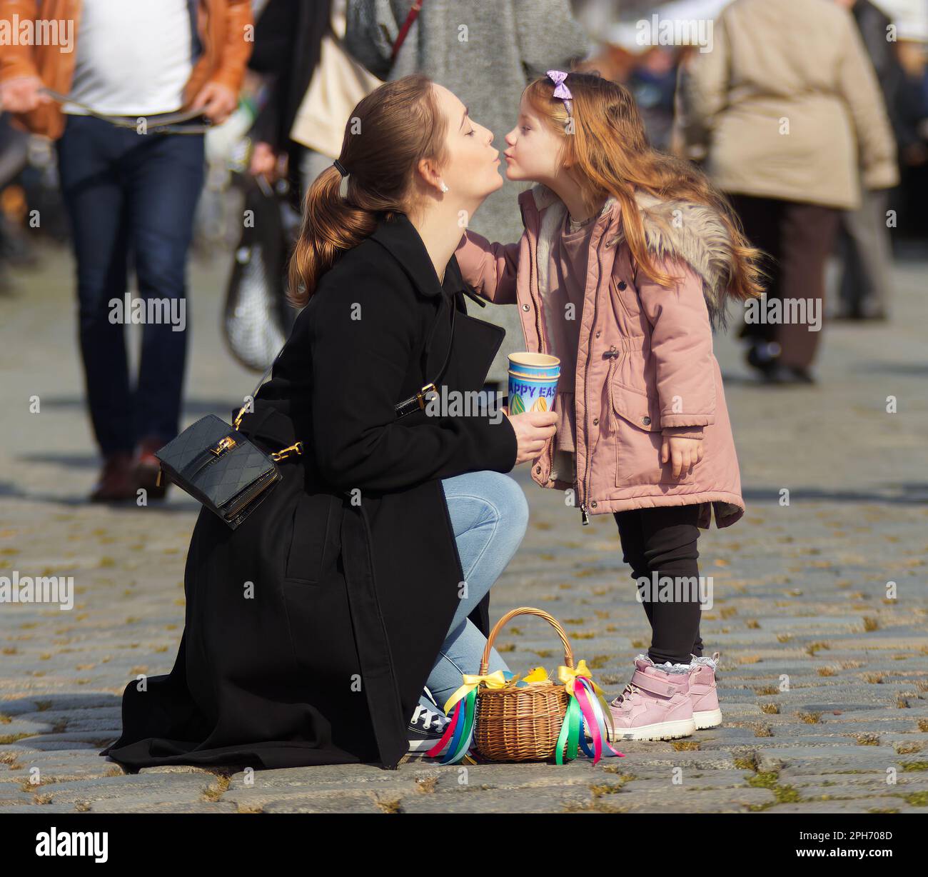 Junge Mutter und ihre kleine Tochter küssen sich nach erfolgreichem Ostereinkauf auf dem Bauernmarkt in Prag. Stockfoto