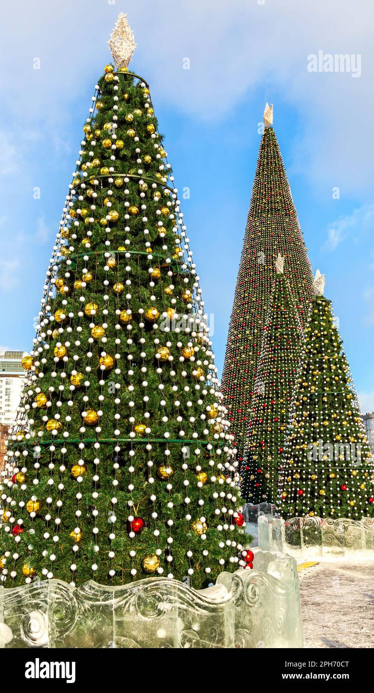 Große dekorierte Weihnachtsbäume mit Bällen an der Straße der Stadt. Neujahrsfeier Stockfoto