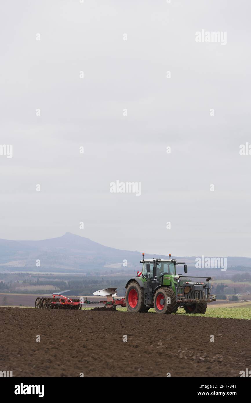 Pflügen in grüner Gülle auf einem Aberdeenshire-Feld vor Bennachie mit einem Fendt-Traktor, der einen Kverneland Reversible Pflug und Doppelpacker schleppt Stockfoto