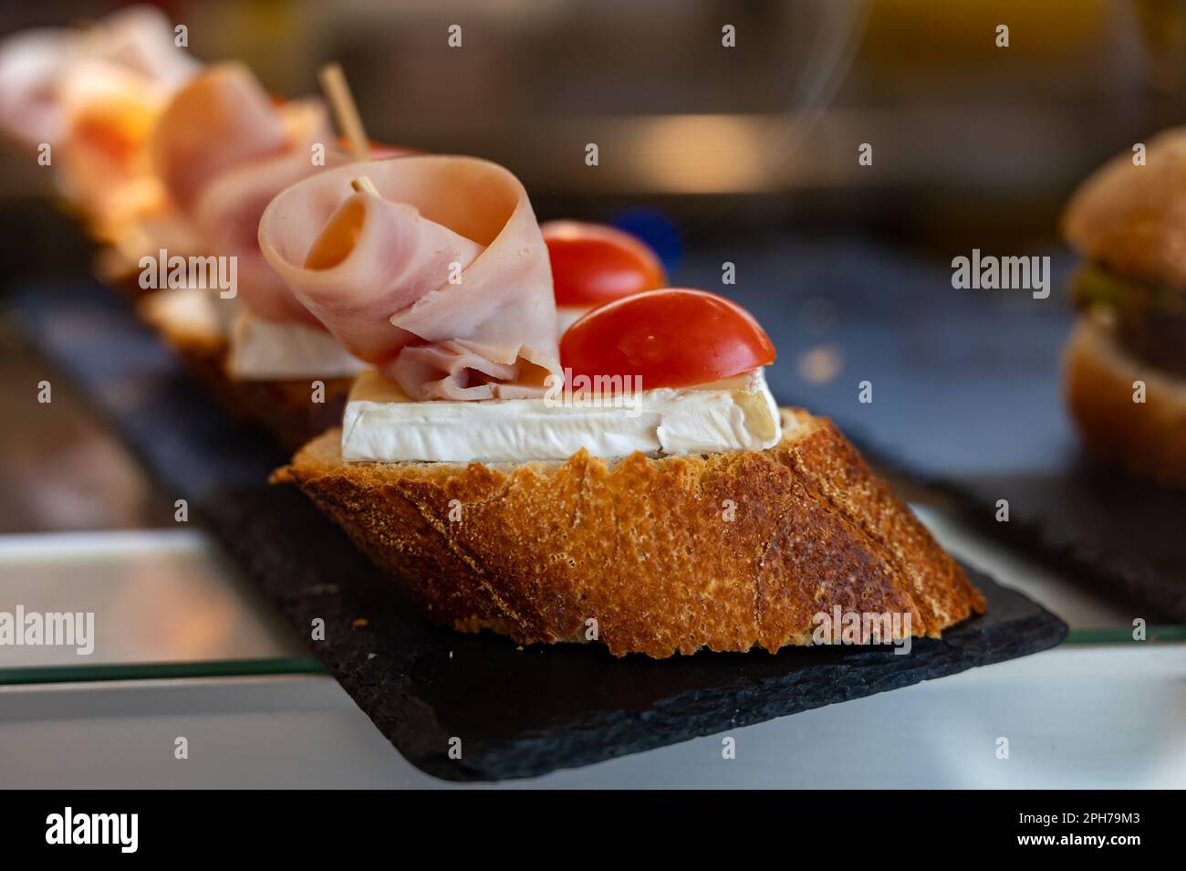 Typischer Mini-Burger-Snack aus dem Baskenland, Pinchos oder Pinxtos, kleines Stück Brot mit verschiedenen Belägen, serviert in der Bar in San-Sebastian oder Bilba Stockfoto