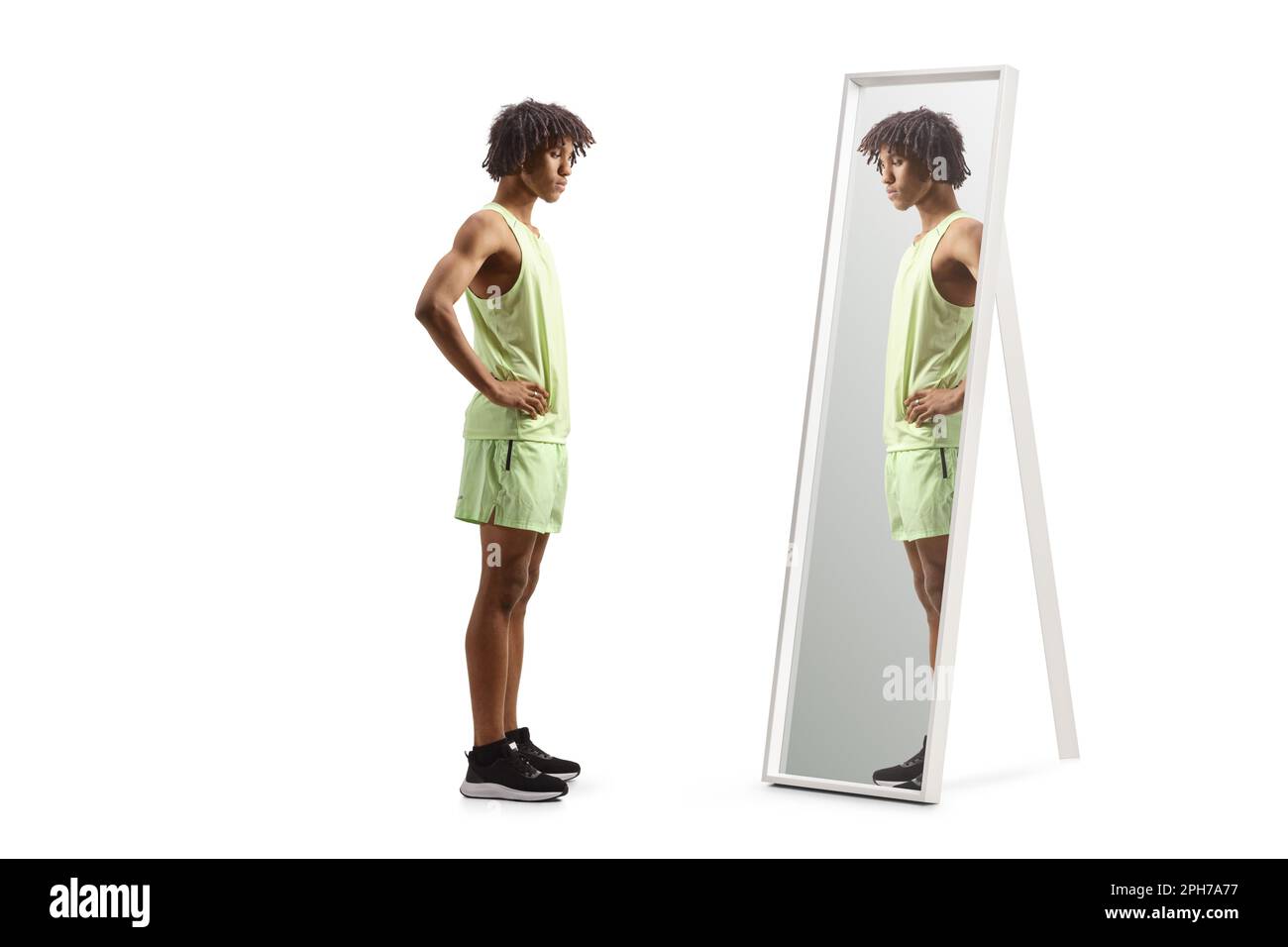 Ein afroamerikaner in Sportbekleidung steht vor einem Spiegel, isoliert auf weißem Hintergrund Stockfoto