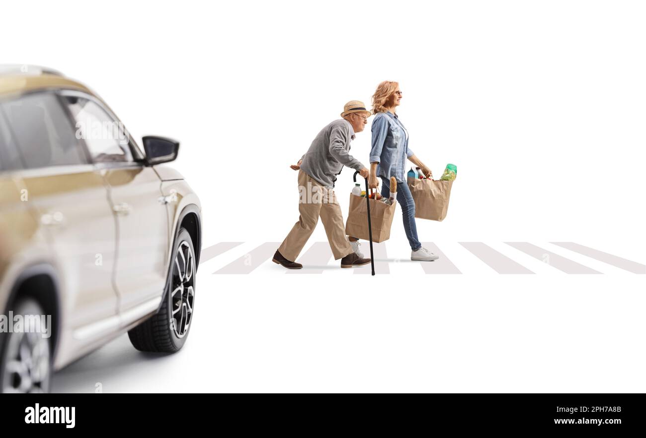 Ein Auto fährt auf einen Fußgängerübergang zu, eine Frau mit einer älteren Dame überquert die Straße und trägt Einkaufstaschen isoliert auf weißem Hintergrund Stockfoto
