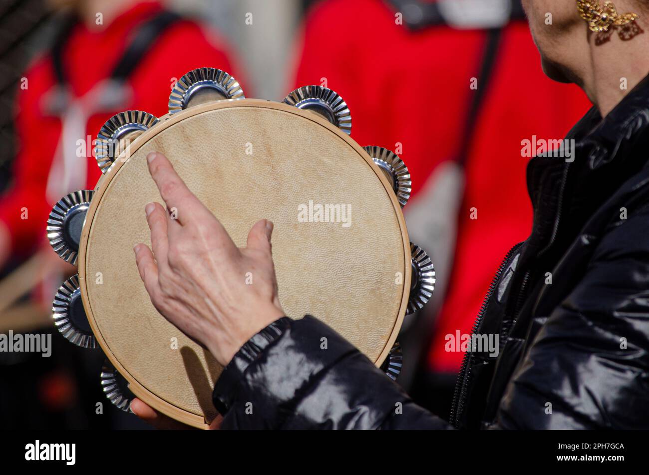 Selektiver Fokus, die Hand einer Frau, die Tamburin in einer traditionellen galizischen Band spielt. Stockfoto