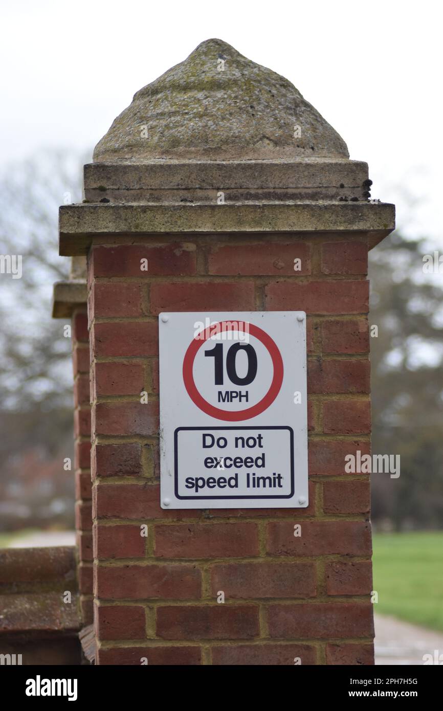 Straßenschild an einer Ziegelmauer in Milton Keynes: „10 km/h überschreiten das Tempolimit nicht“. Stockfoto