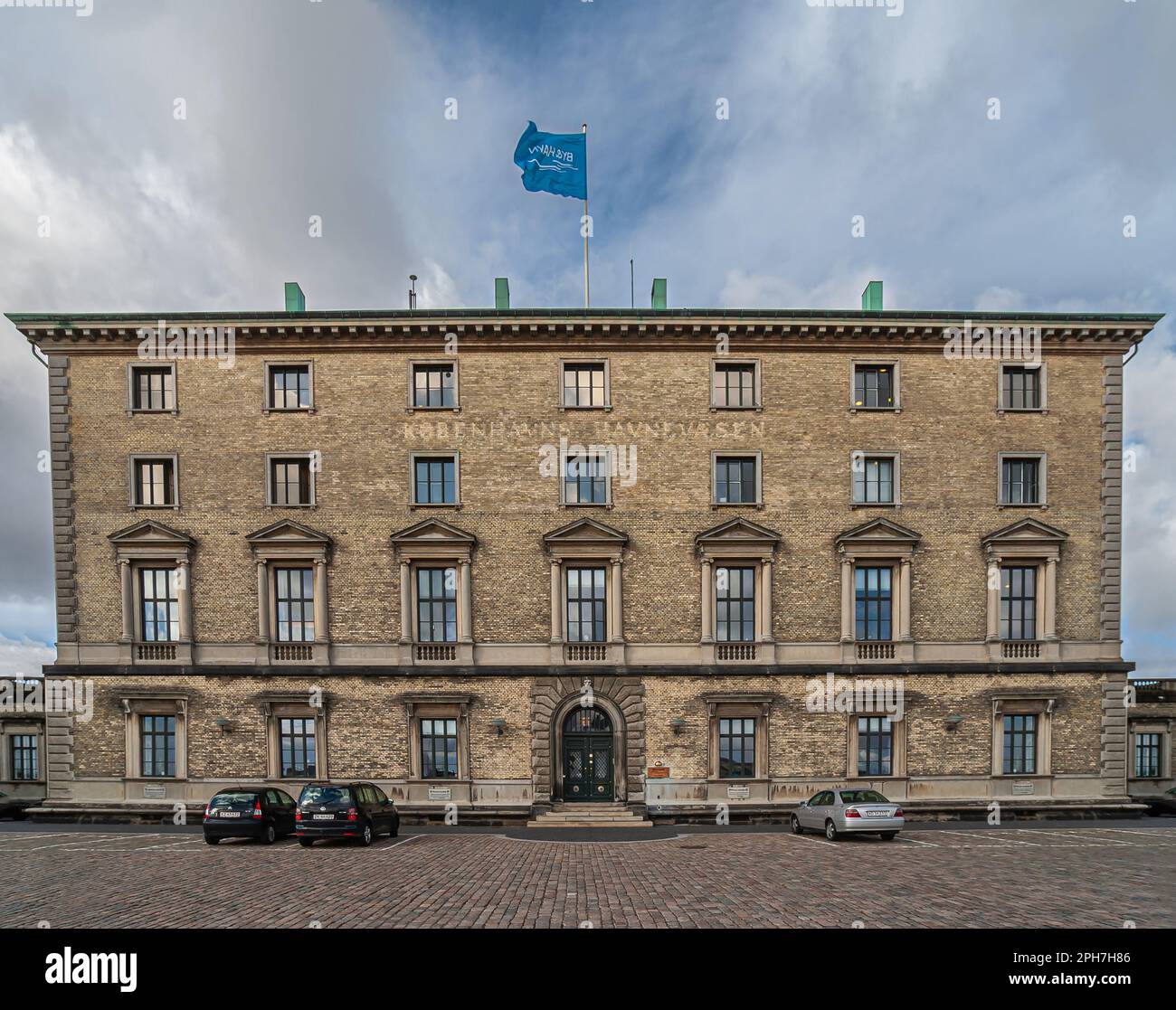 Kopenhagen, Dänemark - 13. September 2010: Historisches Nordre Toldbod, Mauthaus, in braunen Ziegeln mit Fensterreihen und Autos vor dem Hotel. Flagge des Gouverneurs Stockfoto