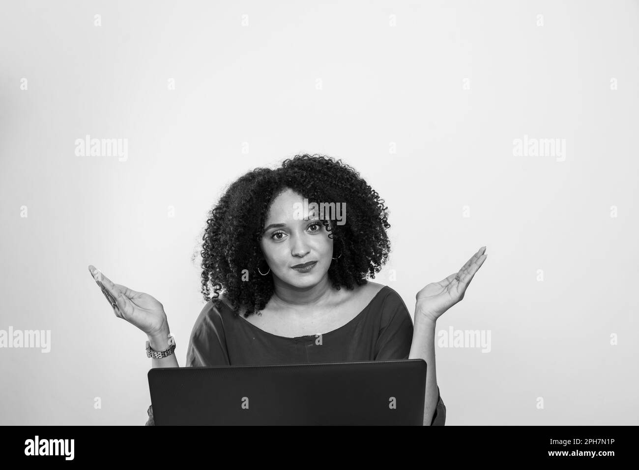 Junge Geschäftsfrau, die an ihrem Laptop arbeitet und in die Kamera schaut. Finanzmanager Stockfoto