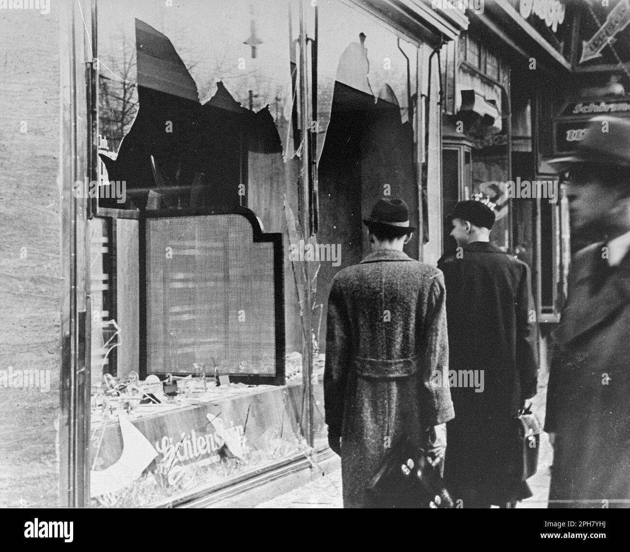 Ein zerstörter jüdischer Laden in einer Straße in Berlin nach Kristallnacht. Kristallnacht war ein landesweites Pogrom, das am 9. November 1938 von der nazi-Partei organisiert und durchgeführt wurde. Geschäfte und Synagogen wurden zerstört und Menschen gedemütigt und geschlagen, während die Polizei zuschaute oder sogar half. Obwohl die Schäden und die Zahl der Angreifer recht gering waren, zeigte die Tatsache, dass sie völlig unangefochten waren, den Nazis, dass sie wirklich mit den Juden anfangen konnten, und ist damit einer der wichtigsten Meilensteine auf dem Weg zum Holocaust. Stockfoto