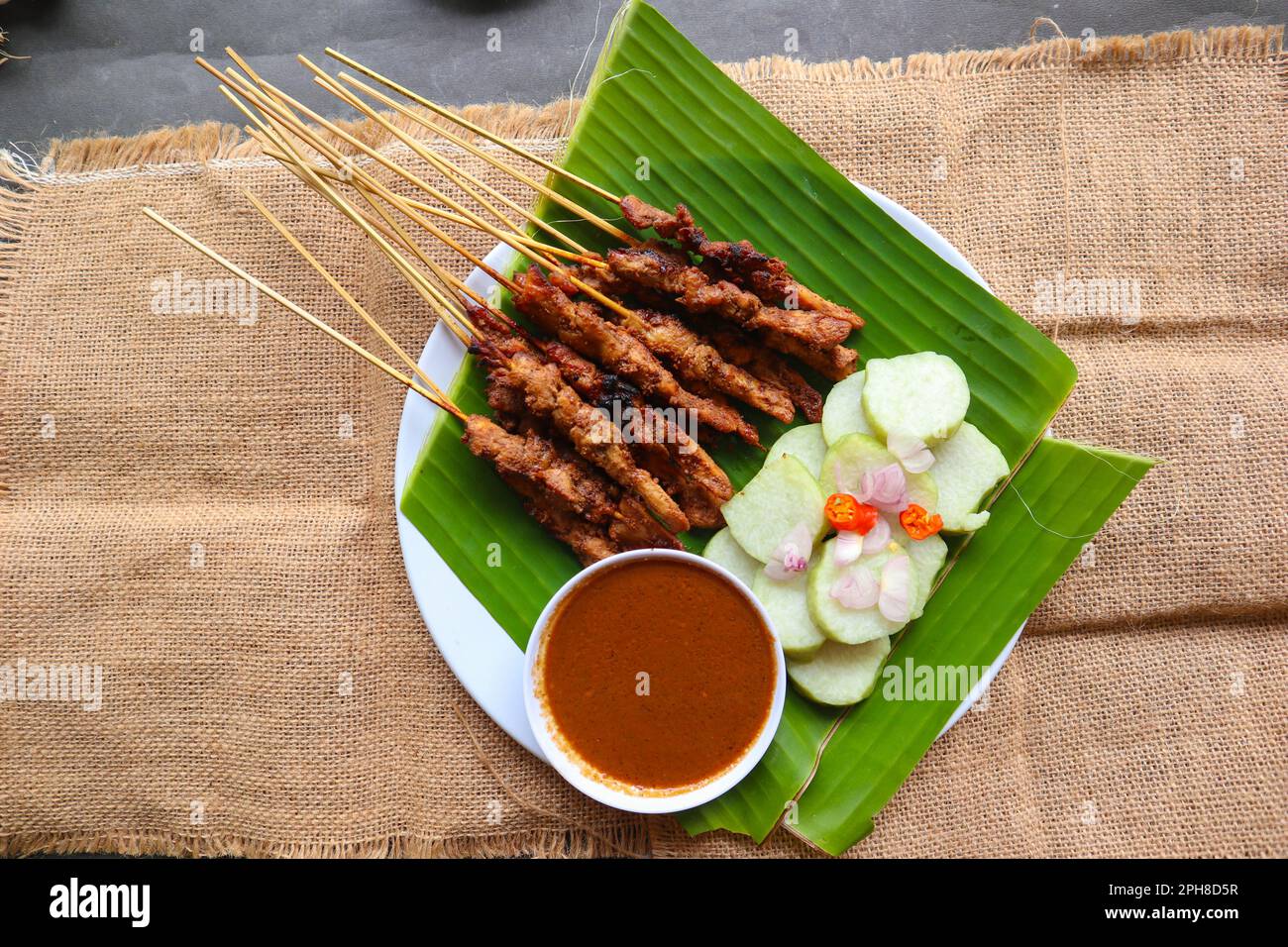 Hähnchen Satay oder Hähnchen Satay serviert mit Longtong, Reiskuchen und Erdnusssoße. Serviert auf Bananenurlaub Stockfoto