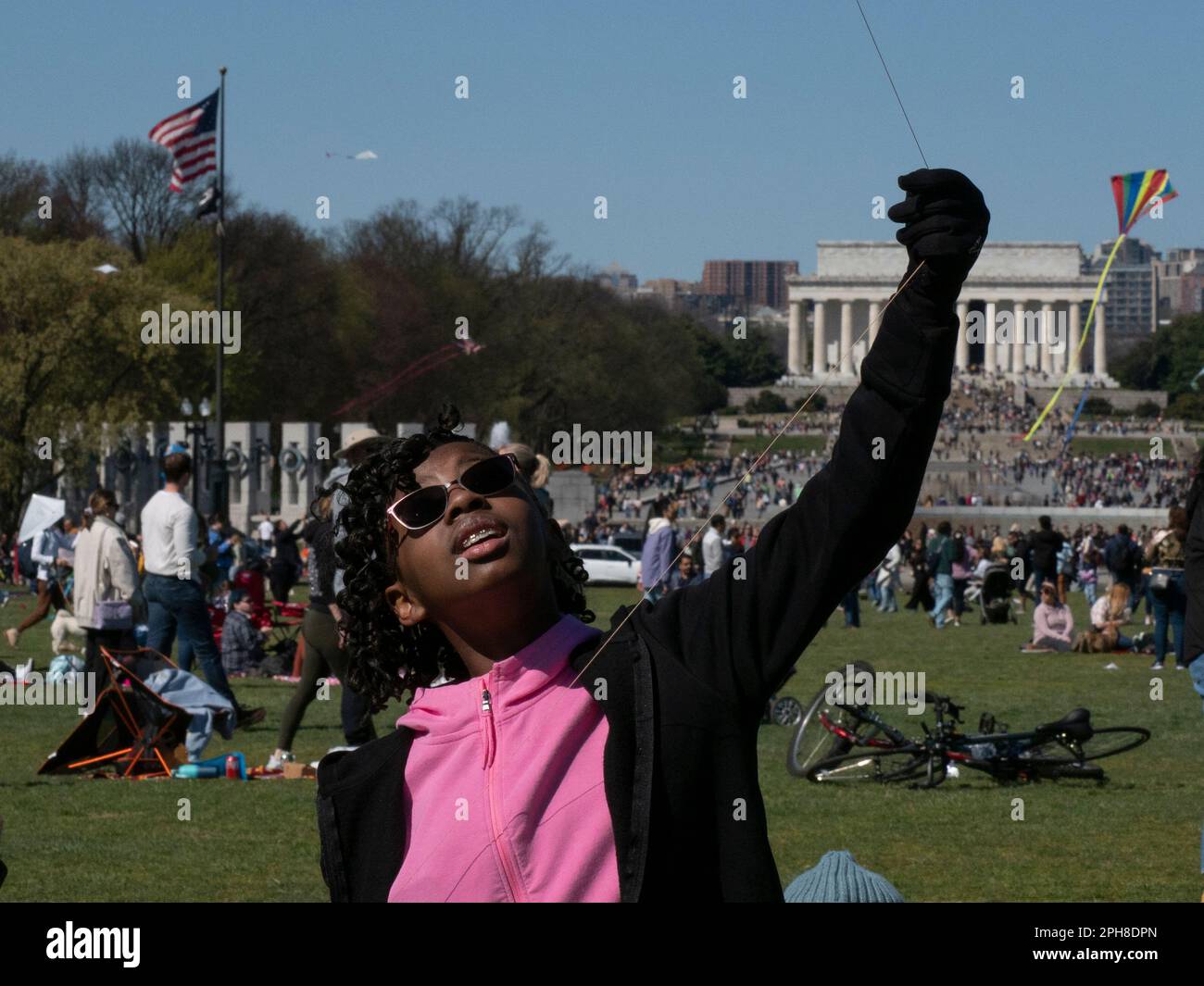 26. März 2023, Washington, District of Columbia, USA: Der ARYELLE Fountain hält sich fest an ihrem Drachen, während Hunderte anderer beim jährlichen Blossom Kite Festival in der National Mall dabei sind. Das Lincoln Monument ist im Hintergrund. (Kreditbild: © Sue Dorfman/ZUMA Press Wire) NUR REDAKTIONELLE VERWENDUNG! Nicht für den kommerziellen GEBRAUCH! Stockfoto