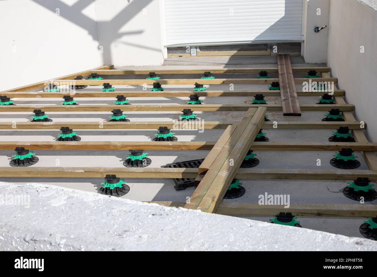 Exotische Holzterrasse auf verstellbaren Kunststoffsockeln auf der Baustelle Stockfoto