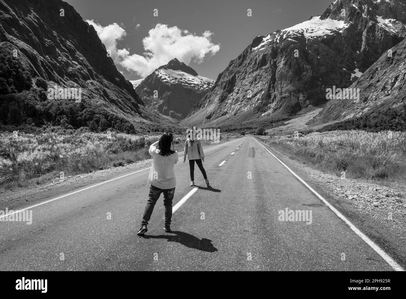 Touristen halten für ein Foto auf dem Milford Sound Highway am Monkey Creek, Fiordland National Park, South Island, Neuseeland Stockfoto