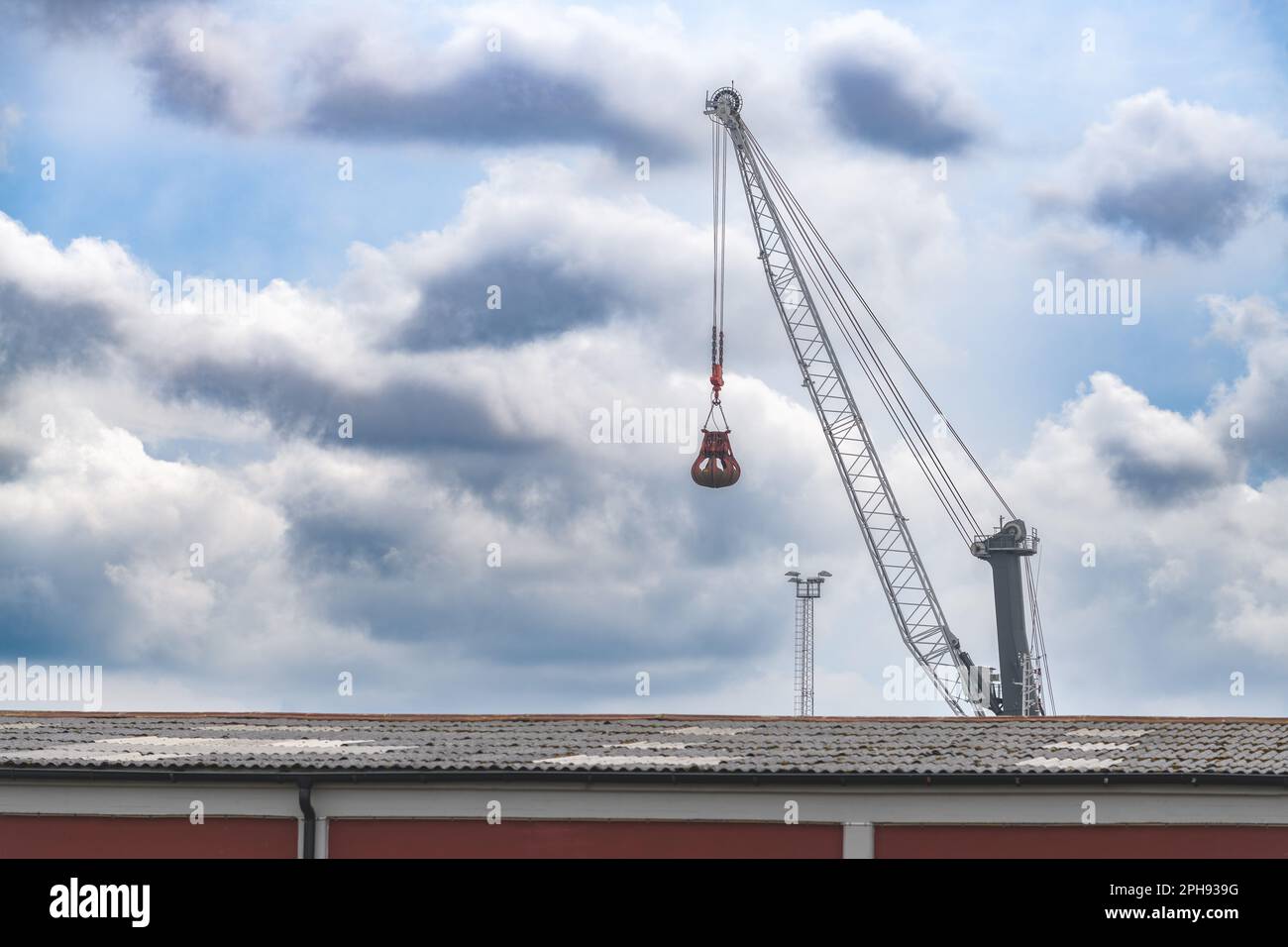 Klauenkranich, Industriemaschinen gegen dramatischen Himmel, selektiver Fokus Stockfoto