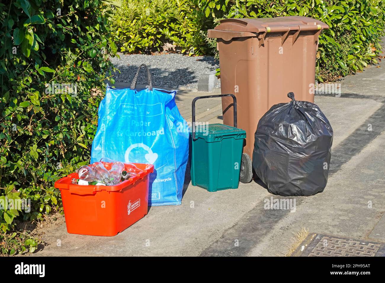 Getrennte Müllabfuhr wöchentliche Sammlung durch den rat Rotglasbehälter blauer Papierkartensack grüner Lebensmittelbehälter braun Wheelie Garten schwarz nicht recycelbar Stockfoto