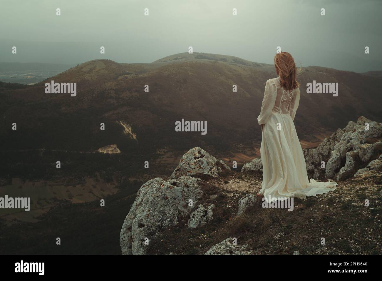 Die Braut allein auf einem Berggipfel Stockfoto