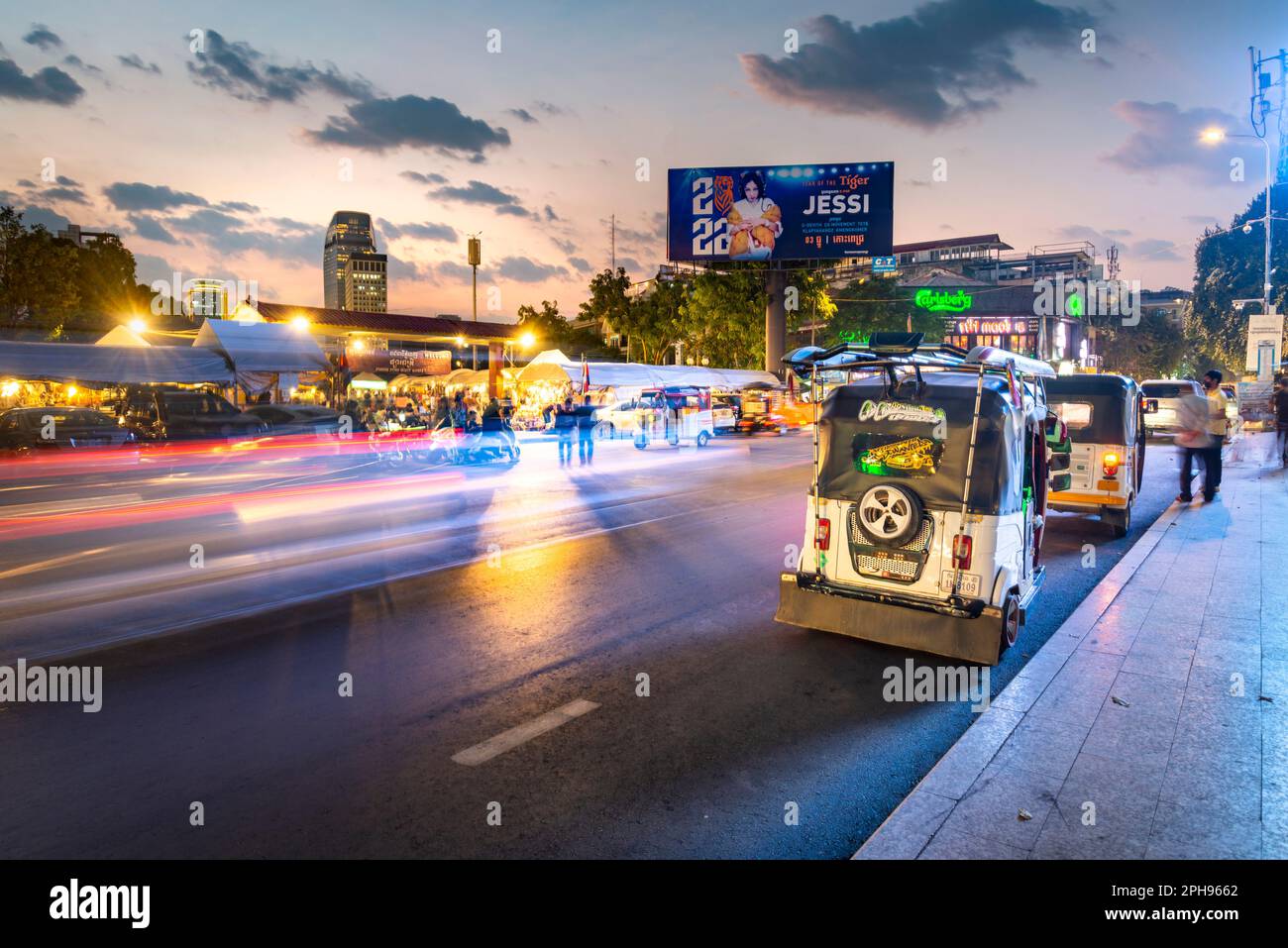 Phnom Penh, Kambodscha-Dezember 23. 2022: Als Licht von vorbeifahrenden Verkehrsstreifen vorbeizieht, erwacht der beliebte Markt in der Dämmerung zum Leben und zieht viele Khmer an Stockfoto