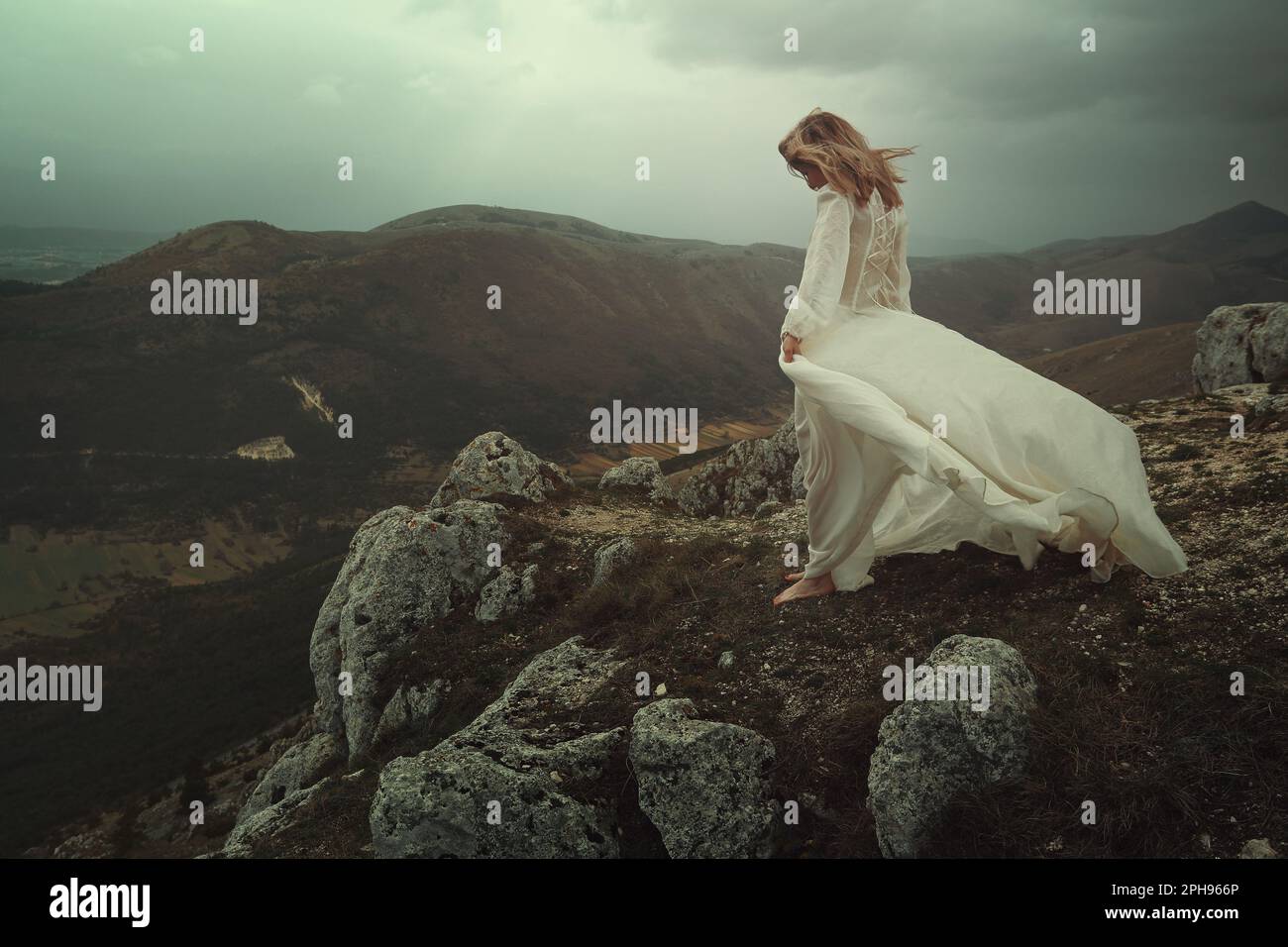 Traurige Frau auf einem windigen Berggipfel Stockfoto