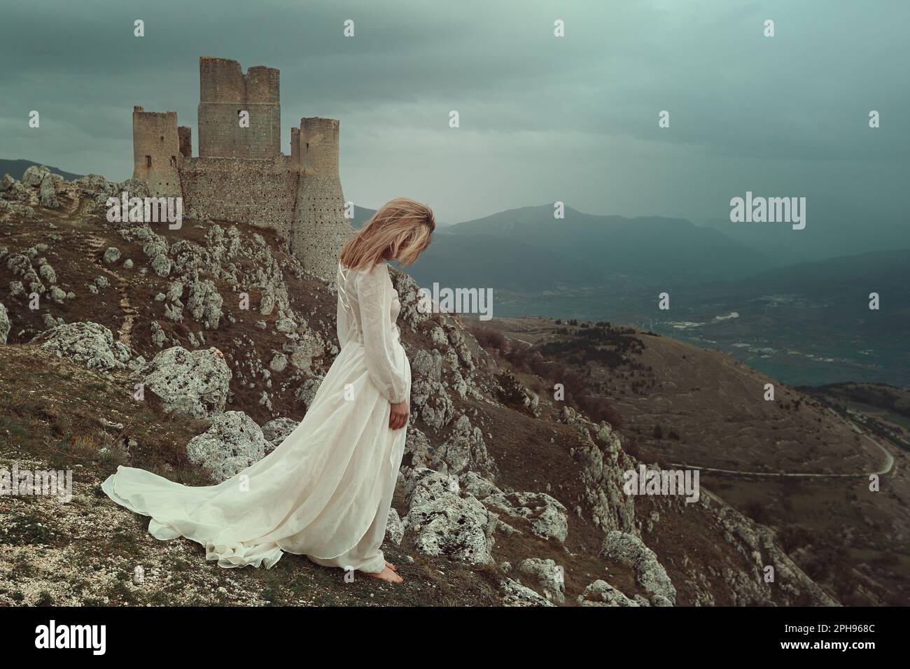 Frau allein mit windigem Schloss von Calascio Stockfoto