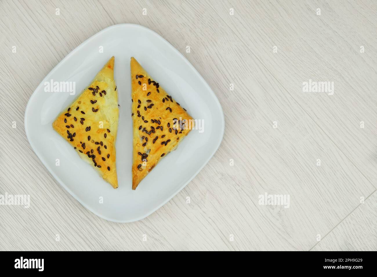 Östliche Küche. Samosas auf einem Teller mit Holzhintergrund. Hausmannskost. Fastfood. Draufsicht. Stockfoto