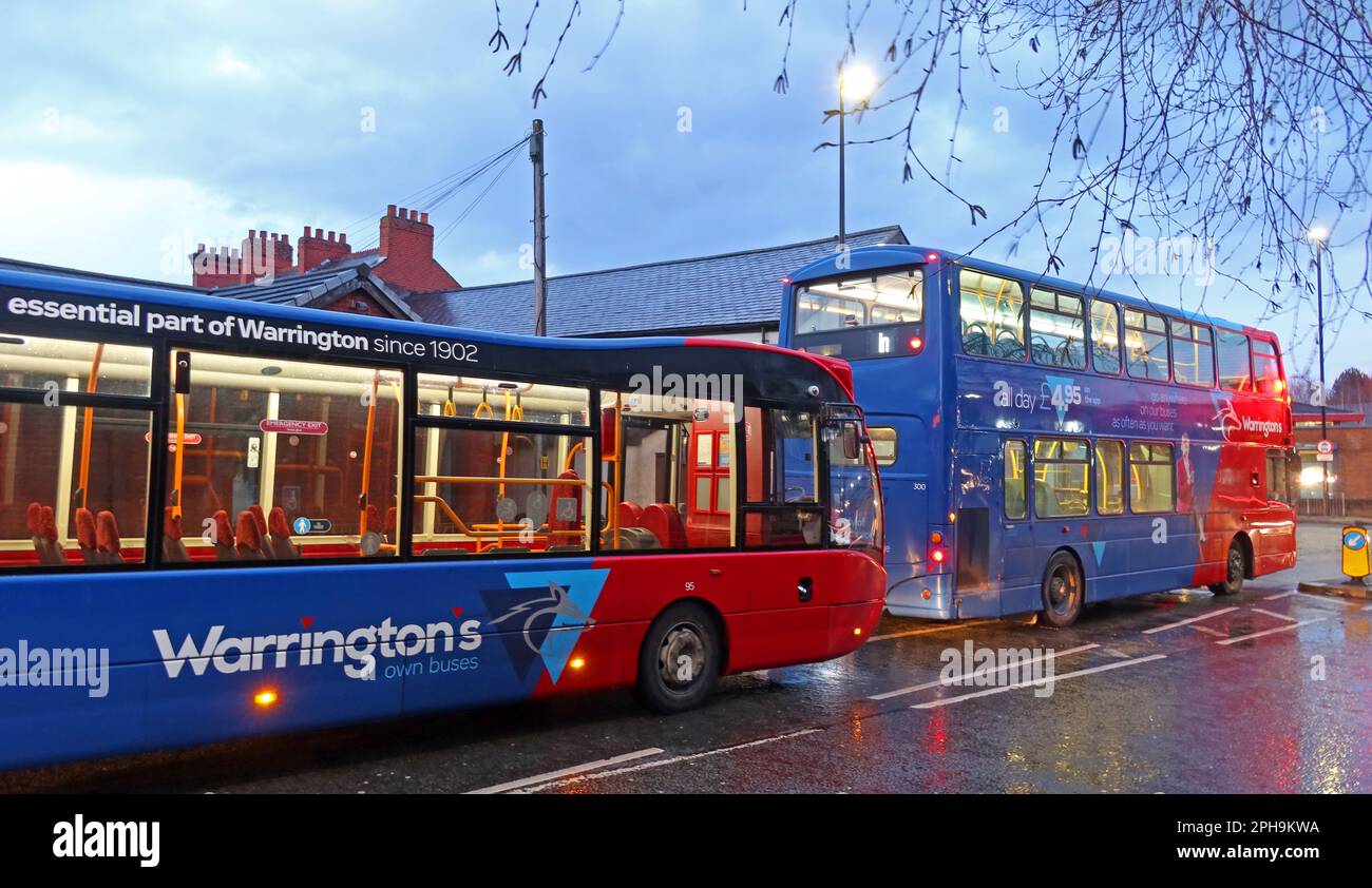 Zwei von Warringtons eigenen Bussen, in der Academy Street, im Stadtzentrum von Warrington, Cheshire, England, Großbritannien, WA1 2BQ bei Dämmerung Stockfoto
