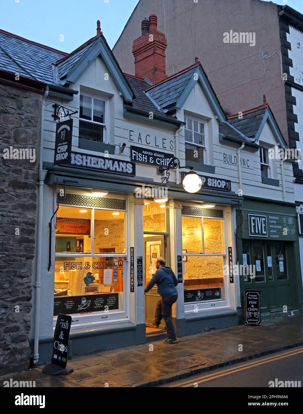 Kunde betritt das Eagles Building, Fishermans Chippy, 3 Castle St, Conwy, North Wales, UK, LL32 8AY Stockfoto