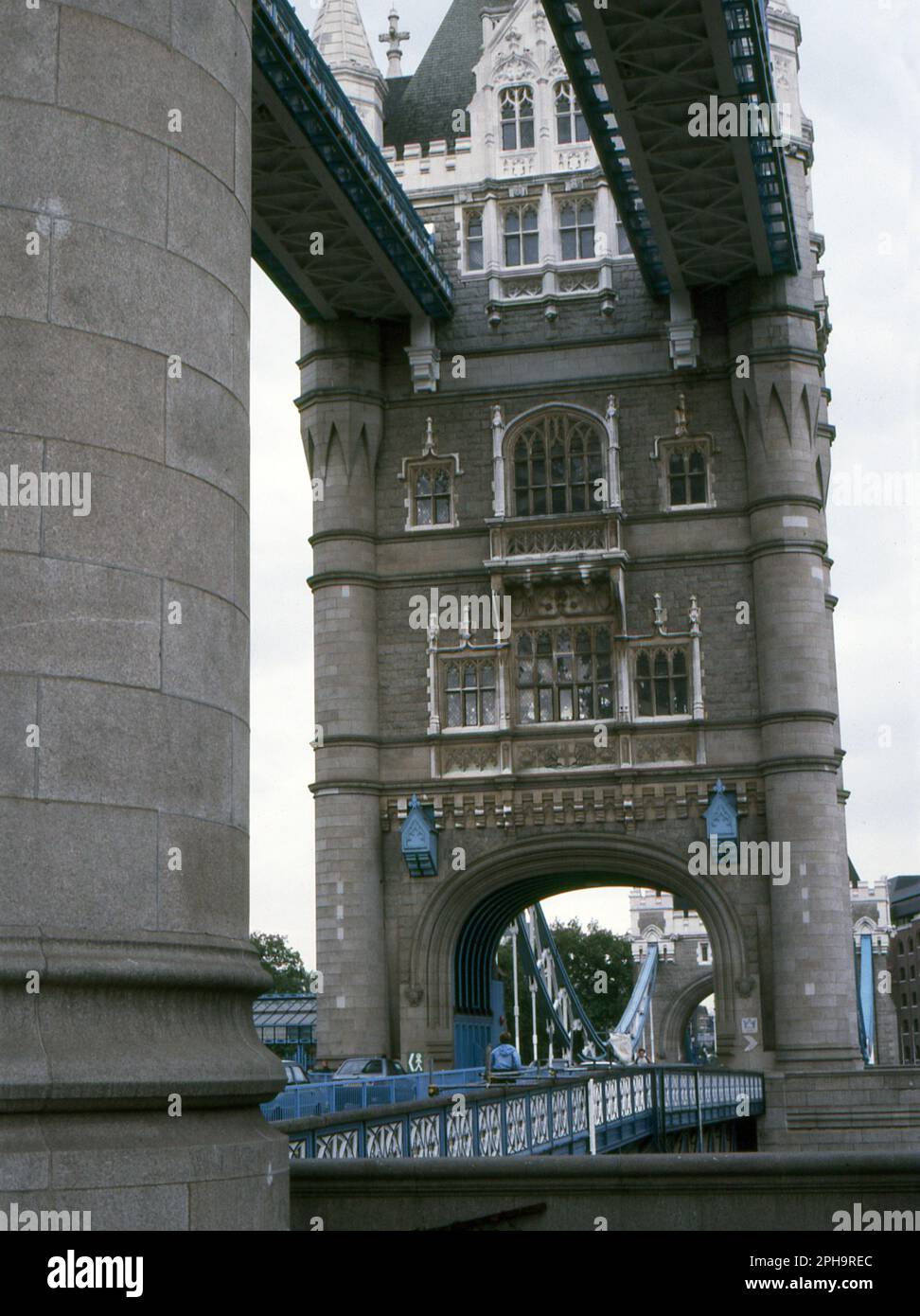 Nach London. 1984. Blick auf den nördlichen Hauptturm, die Baskulen und oberen Fußwege der Tower Bridge, vom Pier des südlichen Hauptturms. Die Brücke erstreckt sich über die Themse in London, England. Stockfoto