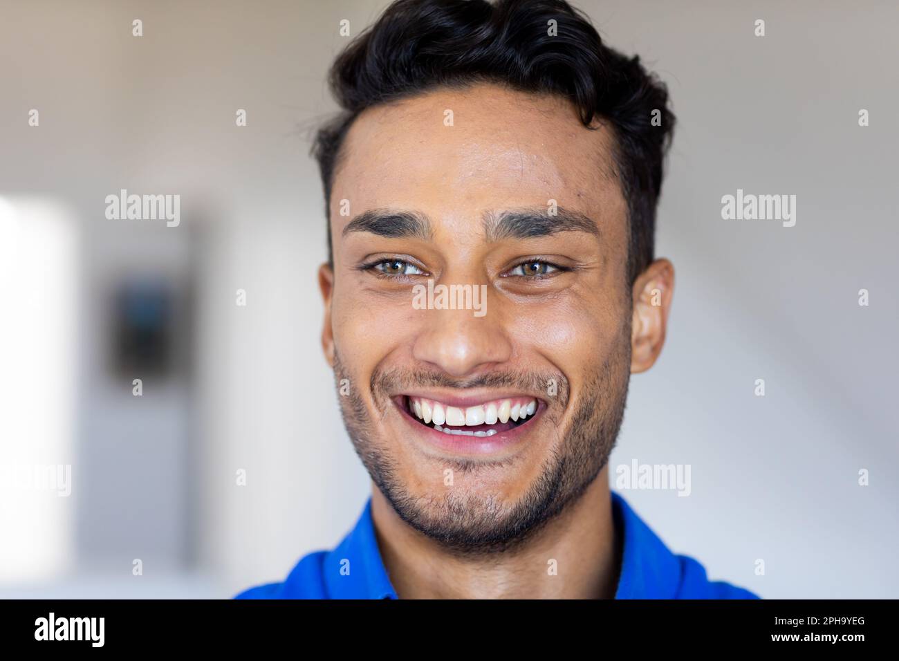 Nahaufnahme eines glücklichen, birassischen Mannes, der lächelt und wegschaut Stockfoto
